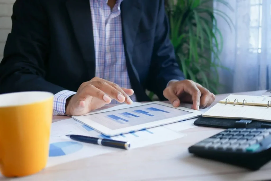Professional reviewing data on a tablet with charts, representing KPI analysis and software performance measurement.
