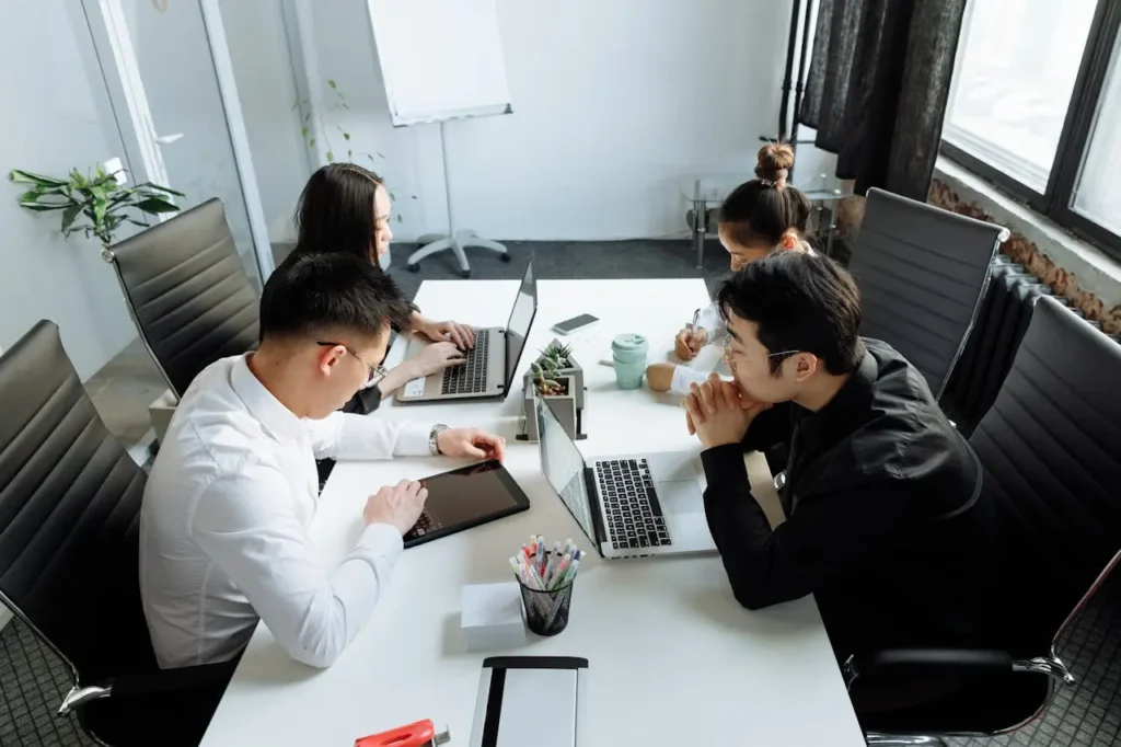Team collaborating with laptops and tablets, representing enterprise software planning and web application development decisions.