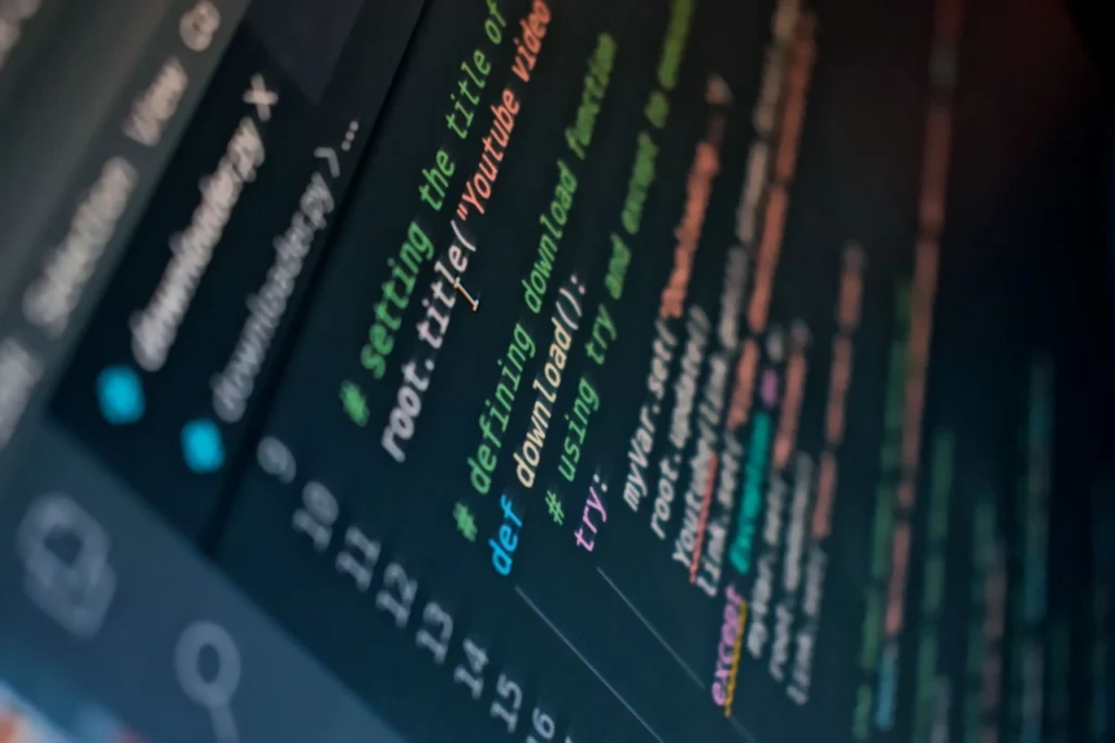 Close-up of programming code on a dark screen, showing a script for downloading a YouTube video.